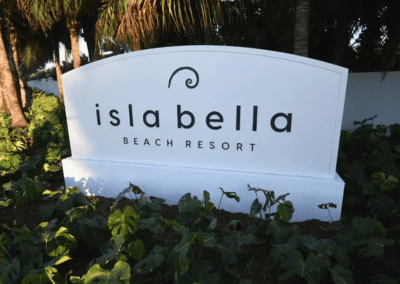 Entrance sign for islabela beach resort surrounded by lush greenery.